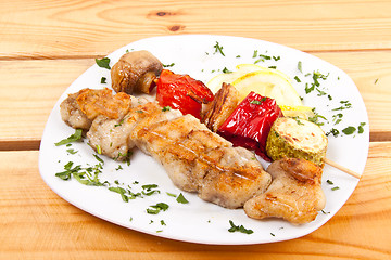 Image showing grilled meat pieces on wood sticks with vegetables