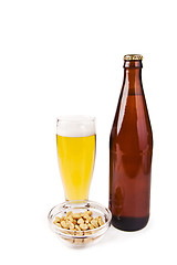 Image showing Beer bottle with glass and salted peanuts isolated