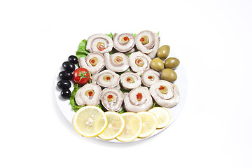 Image showing fish slices served with tomato and olives, and lemon