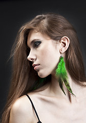 Image showing Young pretty girl with green earrings