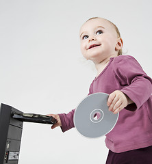 Image showing young child playing with CD