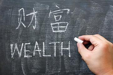Image showing Wealth - word written on a blackboard with a Chinese version