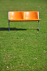 Image showing Orange bench on lawn