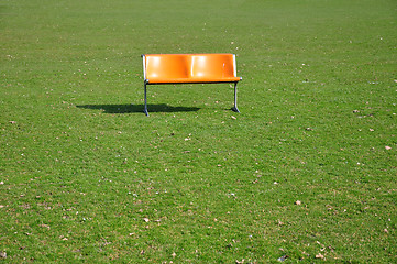 Image showing Orange bench on lawn