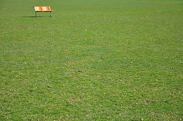 Image showing Orange bench on lawn