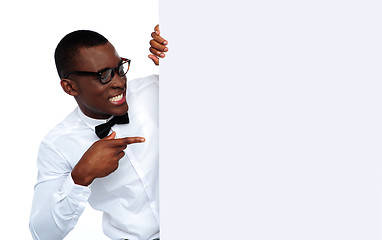 Image showing African young man pointing at blank billboard