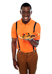 Image showing Smiling young african boy offering pizza