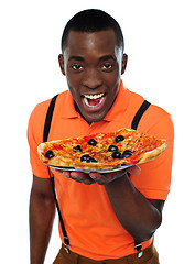 Image showing Boy in uniform offering pizza