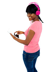 Image showing Girl listening to music via portable tablet