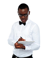 Image showing Confident young man writing on notepad