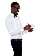 Image showing African employee writing on clipboard