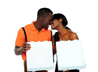 Image showing Black couple kissing and holding pizza boxes