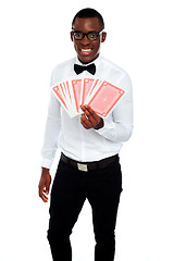 Image showing A man holding up a few playing cards