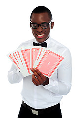 Image showing Young black man holding out deck of cards