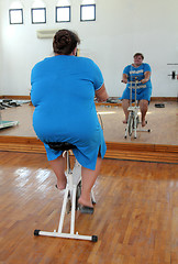 Image showing overweight woman exercising on bike