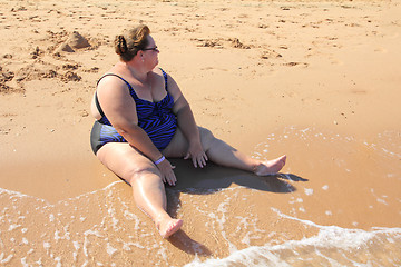 Image showing overweight woman sitting on beach