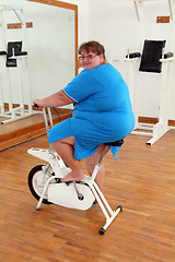 Image showing overweight woman exercising on bike