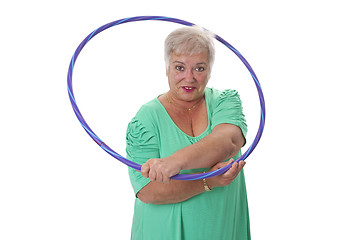 Image showing Senior lady doing gymnastic with hula-hoop