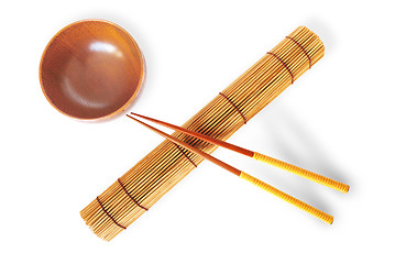 Image showing rolled bamboo mat with a pair of chopsticks  and wooden bowl 