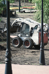 Image showing mini wheel excavator working in city park at the spring