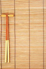 Image showing Chopsticks on brown bamboo matting background 