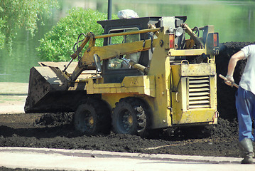 Image showing Mini excavator-grab working in city park  at the spring