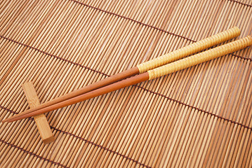 Image showing Chopsticks on brown bamboo matting background 