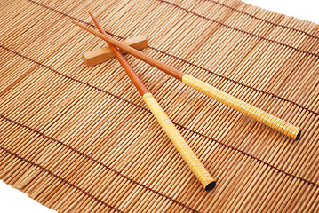 Image showing Chopsticks on brown bamboo matting background 