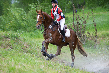 Image showing Eventer on horse is overcomes the Water jump