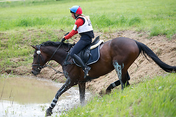 Image showing Eventer on horse is overcomes the Water jump