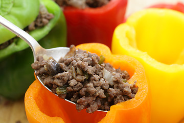 Image showing Stuffing colourful peppers horizontal