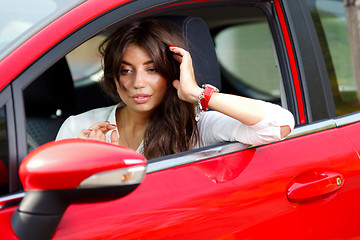 Image showing Young pretty woman in the red car