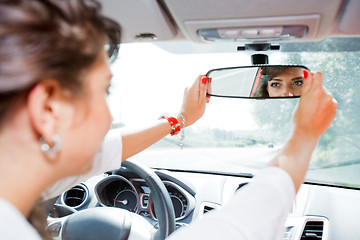 Image showing Young woman corrected rear view mirror