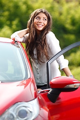 Image showing Young pretty woman in the red car