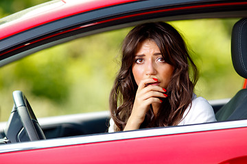 Image showing Young pretty scared woman in the car