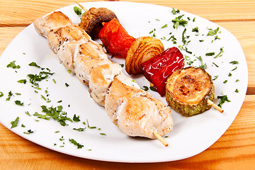 Image showing grilled meat pieces on wood sticks with vegetables