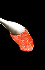 Image showing piece of meat on a fork isolated on black