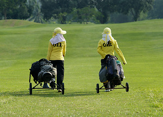 Image showing Two caddies on a golf course