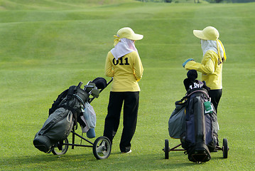 Image showing Two caddies at a golf course