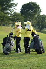 Image showing Two caddies at a golf course