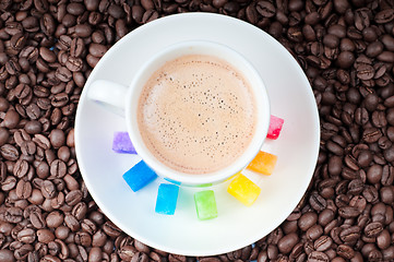 Image showing Multicolored slabs of shugar and cup of coffee