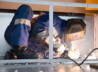 Image showing Welder working in cramped conditions