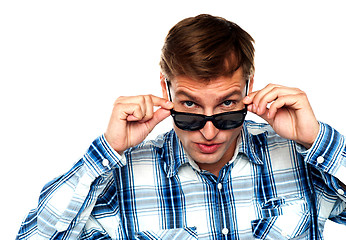 Image showing Confident young man peeping from goggles