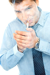 Image showing Young man lighting a cigarette