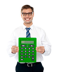 Image showing Male executive displaying green calculator