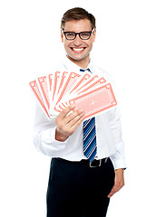 Image showing Cheerful man holding up playing cards