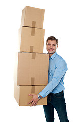 Image showing Smiling male holding stack of cartons