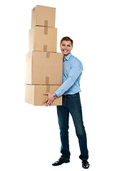 Image showing Young man with stack of cartons