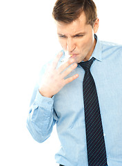 Image showing Young corporate male smokes a cigarette