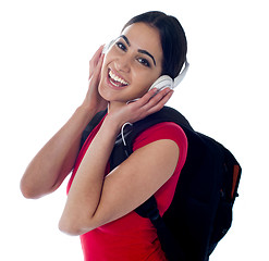 Image showing Cheerful pretty teen listening to music